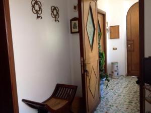 przedpokój z drewnianymi drzwiami i krzesłem w obiekcie Casa Valentino w mieście Capri