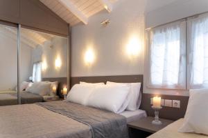 a bedroom with two beds with white pillows and a window at Villa Pearl in Polykhrono