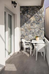 un tavolo e sedie su un patio con parete in pietra di Villa Pearl a Polykhrono
