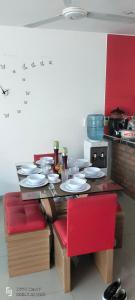 a table with plates and red chairs in a kitchen at Casa Veraneo Flandes con Piscina Privada in Flandes