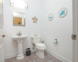 Un baño blanco con inodoro y lavabo. en Pelican Roost 9407 home, en Gulf Highlands