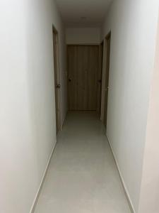 卡塔赫纳Confortable apartamento cerca al mar y centro histórico的一条空的走廊,有门和白色的墙壁 更多1张照片