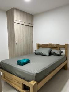 卡塔赫纳Confortable apartamento cerca al mar y centro histórico的一张带蓝色枕头的木床