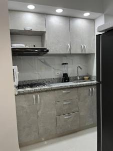 卡塔赫纳Confortable apartamento cerca al mar y centro histórico的厨房配有不锈钢橱柜和黑冰箱。