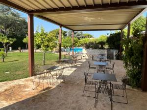 un groupe de tables et de chaises sous un pavillon dans l'établissement Executive L'Orangerie BB, à Bari