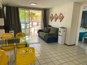 a living room with a couch and a table and chairs at Ancorar Flat in Porto De Galinhas