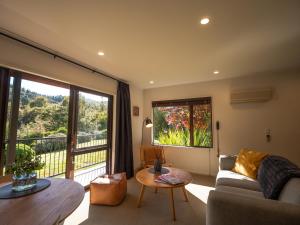 a living room with a couch and a large window at Maruia River Retreat in Shenandoah