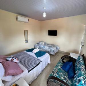 a room with two beds and a couch in it at Pousada La Belle de Jour in Chapada dos Guimarães