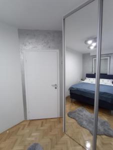 a bedroom with a bed and a mirror at STAN NA DAN BIJELJINA in Bijeljina