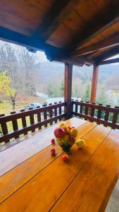 a bowl of fruit on a wooden table on a porch at Apartments Lux Labovic in Kolašin