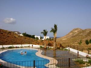 a swimming pool with two people in the water at book now spacious 12p villa with communal pool in Las Negras