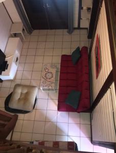 - un salon avec un canapé rouge et une chaise dans l'établissement Montabo duplex, à Cayenne