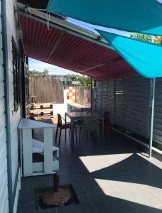 eine Terrasse mit einem Tisch, Stühlen und einem Sonnenschirm in der Unterkunft Montabo duplex in Cayenne