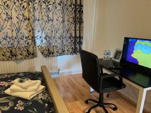 a room with a desk and a chair and a computer at Park View Serviced Apartment - Next to Northolt Tube Station - Near Central London & Wembley in Northolt