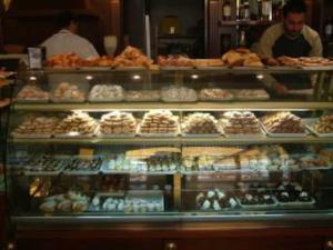 a display case in a bakery filled with lots of pastries at Stignano Mare, near Caulonia, Calabria, Italy in Focà