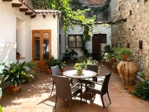 un patio con mesa, sillas y plantas en Ca Roc, en Fatarella