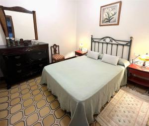 1 dormitorio con cama, tocador y espejo en Ca Roc, en Fatarella