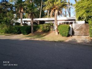 une maison avec des palmiers sur le côté d'une rue dans l'établissement Verano, à Punta del Este