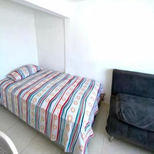 1 dormitorio con 1 cama y 1 silla en 2023 Apartamento Amoblado 4 Habitaciones Familias- Grupos 8 a 9 Personas, en Santa Marta