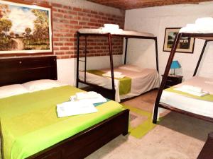 a room with three bunk beds and a brick wall at CASA CAMPESTRE VILLA PAULA - Finca 