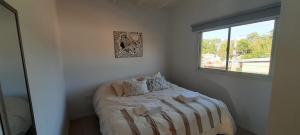 a small bedroom with a bed with a window at Amplio departamento a estrenar ! in Godoy Cruz
