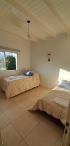 a bedroom with two beds and a window at Amplio departamento a estrenar ! in Godoy Cruz