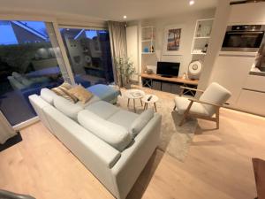 sala de estar con sofá blanco y sillas en Saint Palais- Sincfal 26 en Cadzand