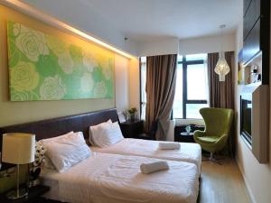 a hotel room with a bed and a green painting at PJ13 1ooMbpsSweetSty3Pax at PJCentrestage in Petaling Jaya
