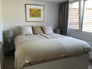 Dormitorio blanco con cama y ventana en Saint Palais- Sincfal 26 en Cadzand