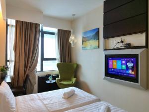 a hotel room with a bed and a tv on the wall at PJ13 1ooMbpsSweetSty3Pax at PJCentrestage in Petaling Jaya