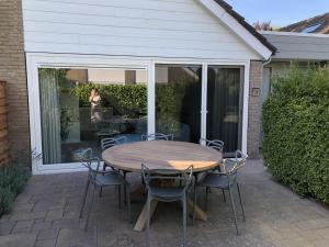 een houten tafel en stoelen op een patio bij Saint Palais- Sincfal 26 in Cadzand