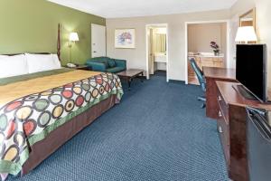 a hotel room with a bed and a desk at Super 8 Carrollton in Carrollton