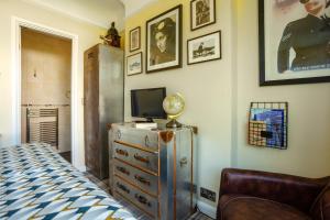 a bedroom with a bed and a tv on a dresser at Twentieth Century B&B in Birchington