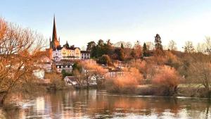 a large house on a hill next to a river at The Snug in Goodrich