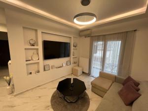 uma sala de estar com um sofá e uma televisão de ecrã plano em Luxurious Apartment in the Heart of Thessaloniki em Tessalônica