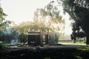 a small green building in a field with trees at CABN McLaren Vale in McLaren Flat