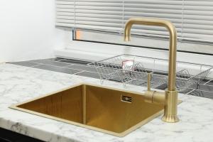 a kitchen sink with a basket on a counter at Plymouth Hoe - Beautiful 5 Bedroom Victorian House - Central Location in Plymouth