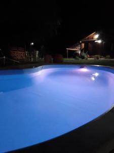 una piscina con iluminación azul por la noche en cabañas Khuska en Bialet Massé
