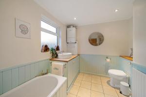 uma casa de banho com uma banheira, um WC e um lavatório. em Spacious home with garden Heart of the town WiFi Smart TV em Cirencester