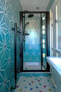 a bathroom with a shower with blue and white tiles at Twentieth Century B&B in Birchington