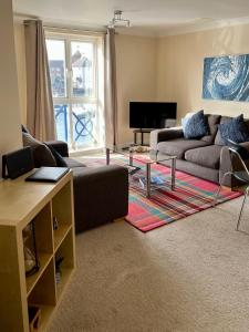 sala de estar con sofá y mesa en Fabulously located Marina apartment - marina views, en Pevensey