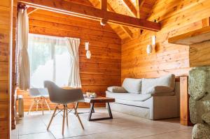 a living room with a couch and a table at BOG Jardin de Flores in Villa La Angostura