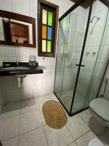 a bathroom with a shower and a sink and a toilet at Bem Natural Pousada in Praia de Araçatiba