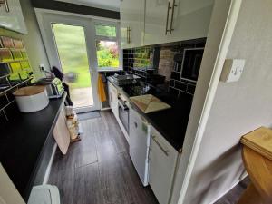 eine Küche mit schwarzen und weißen Arbeitsflächen und einem Waschbecken in der Unterkunft Ranger - Snowdon Cabins holiday let Caernarfon in Caeathro
