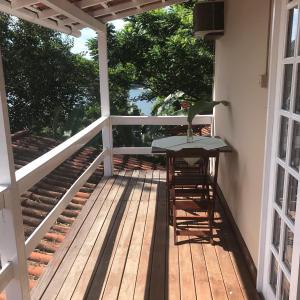 un patio con mesa y sillas en una terraza en Bem Natural Pousada en Praia de Araçatiba