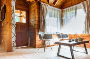 Pokój z 2 krzesłami, stołem i oknem w obiekcie BOG Jardin de Flores w mieście Villa La Angostura