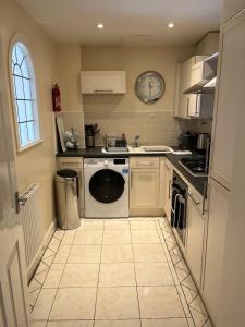 cocina con lavadora, fregadero y lavavajillas en Fabulously located Marina apartment - marina views, en Pevensey