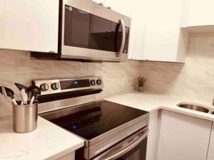 a kitchen with a microwave and a stove top oven at unit #301 Mountain view 2BR in Canmore Down town in Canmore +7 photos