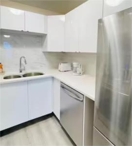 cocina blanca con fregadero y nevera en unit #301 Mountain view 1BR in Canmore Down town, en Canmore