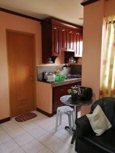 a kitchen with brown cabinets and a table in a room at Cranberry's place #3 in Iloilo City